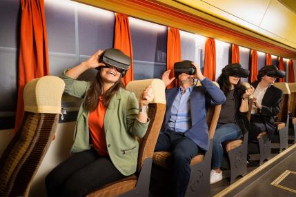 People wearing Virtual Reality glasses in a train